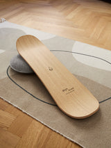 Produktfoto des dryBoard Balance Board Snowboard aus Holz auf einem Teppich mit dryDrop. 